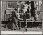 Migratory laborers playing checkers in front of juke joint during slack season for vegetable pickers. Belle Glade, Florida.