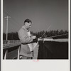 Guest of Sarasota trailer park, Sarasota, Florida, adjusting fishing rod.