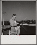 Guest of Sarasota trailer park, Sarasota, Florida, adjusting fishing rod.