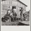 Migratory laborers playing checkers in front of jook joint during slack season for vegetable pickers. Belle Glade, Florida.