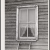 Window frame with screen supplied. The top strip has been nailed in place. The screen is then stretched and fastened at the sill. Screening demonstration. Charles County, La Plata, Maryland.
