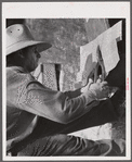 Cutting metal reinforcing for corners. Screen door construction demonstration. Charles County, La Plata, Maryland.