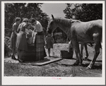 Home supervisor while making home visit to FSA (Farm Security Administration) borrower inspects water supply for repair. Charles County near La Plata, Maryland.
