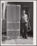 Door frame with screen wire assembled ready to fasten on hinge strip. Screening demonstration. Charles County, La Plata, Maryland.