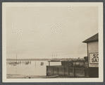 View of Greenport Harbor, showing wharves, boats, and Shelter Island in the distance. Greenport, Southold