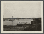 View of Greenport Harbor, from a point near railroad depot, showing boats and Shelter Island in the distance. Greenport, Southold