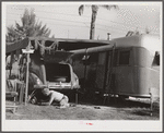 One of the guests at Sarasota trailer park, Sarasota, Florida, washing his car. He has named his trailer home "Loveless".
