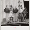 Spanish trapper's wife and sister-in-law holding dried muskrat skins in front of their camp in the marshes near Delacroix Island, Louisiana.