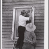 Side strips are nailed over the wire sceen to hold the edges down tightly. A completed window screen. Screening demonstration. Charles County, La Plata, Maryland.