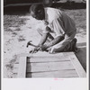 Assembling a joint of screen door. Screen door stock used is one inch by four inches. Joints are cut square and held together with corrugated fasteners. Screening demonstration. Saint Mary's County, Ridge, Maryland.