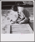 Assembling a joint of screen door. Screen door stock used is one inch by four inches. Joints are cut square and held together with corrugated fasteners. Screening demonstration. Saint Mary's County, Ridge, Maryland.