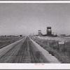Grain storage elevators and highway through Lone Tree, North Dakota.