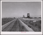 Grain storage elevators and highway through Lone Tree, North Dakota.