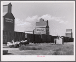 Loading freight on to wagon from station platform as the freight train is leaving Homestead, Montana.