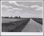 Highway, showing grain elevators and part of town of Froid, Montana.