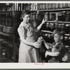 Mrs. Harvey Renninger and son in her home with canned goods. Two River Non-Stock Cooperative, FSA (Farm Security Administration) coop. Waterloo, Nebraska.