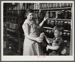 Mrs. Harvey Renninger and son in her home with canned goods. Two River Non-Stock Cooperative, FSA (Farm Security Administration) coop. Waterloo, Nebraska.