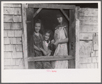 Mrs. Patrick Dumond and two of her children at back door of their home in Lille, Maine. French-Canadian potato farmer and FSA (Farm Security Administration) clients.