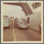 Adults standing by car