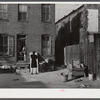 Negro slums. Alexander Court between K and L streets, N.W. Woman and her two children have lived in four small rooms eight and one half years and pay twelve fifty a month for rent ... Washington, D.C.