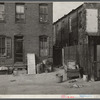 Negro slums. Alexander Court between K and L Streets N.W. A woman and her two children lived in four small rooms eight and one half years and pay twelve fifty a month for rent. Water and privy in the yard. Rents in nearby houses have gone up but not here.