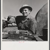 Elmer Womack, derrick man from Fairfax, Oklahoma overhauling mud hog where oil well is being drilled in Goodrich field of Continental oil company. Valley Center oil field near Wichita, Kansas. He has been working in Kansas fields about six years, used to