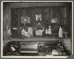 Thurston and company performing on stage, girl standing on chest in center stage