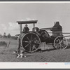Hired man working tractor engine used for threshing on farm of Alfred Shaffner, a farmer in the submarginal area of Sugar Hill, near Townsend, Connecticut.