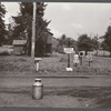 Road intersection with milk can waiting to be picked up by delivery truck. Townsend, New York.