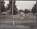 Road intersection with milk can waiting to be picked up by delivery truck. Townsend, New York.