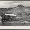 Man in front of his stone house.