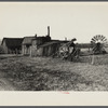 Exterior of workshop and portable windmill for grinding grain on land to be optioned near Ithaca, New York, Tompkins County. Twenty years ago the farmer backed into his wife with their Model T Ford.