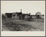 Exterior of workshop and portable windmill for grinding grain on land to be optioned near Ithaca, New York, Tompkins County. Twenty years ago the farmer backed into his wife with their Model T Ford.
