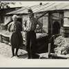 Mr. and Mrs. Thompson standing in front of their log and peat cabin. Thompson reckoned that he had had three crops out of nine on the land. Necedah project, Wisconsin.