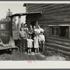 Family group, Yankoskis, standing by their front door. A log house. Beltrami Island reforestation project, Minnesota.