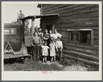 Family group, Yankoskis, standing by their front door. A log house. Beltrami Island reforestation project, Minnesota.