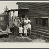 Family group, Yankoskis, standing by their front door. A log house. Beltrami Island reforestation project, Minnesota.