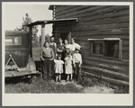 Family group, Yankoskis, standing by their front door. A log house. Beltrami Island reforestation project, Minnesota.