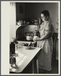 Homesteader canning vegetables in her new kitchen. Austin Homesteads, Minnesota.