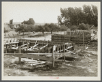 Foundation forms for homes under construction at the Resettlement Administration project, Ironwood, Michigan. Farm buildings in process of removal at left.