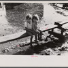 Children sitting on one of the boardwalks which are as sidewalks in the slum area known as "El Fangitto" (The Mud) in San Juan, Puerto Rico.