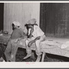 Migratory agricultural workers waiting to go on night shift at the grading station at Camden, North Carolina.