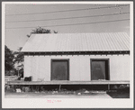 Warehouse that provides housing for a number of migratory agricultural workers. On the left is the baggage of some of the new arrivals. Camden, North Carolina.