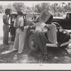 Migrants repairing motor before leaving Old Trap, North Carolina, for New Jersey.