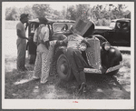 Migrants repairing motor before leaving Old Trap, North Carolina, for New Jersey.
