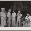 Group of migratory agricultural workers at grading station at Belcross, North Carolina, stop to wash and have their supper.