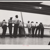 Migratory agricultural workers crossing from Norfolk to Cape Charles on the ferry. This group has just finished picking potatoes in North Carolina and is going to Onley, Virginia.