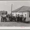 Migratory agricultural workers getting in line to be paid for picking beans. They get seven cents a hundred pounds.