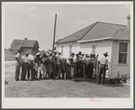Migratory agricultural workers getting in line to be paid for picking beans. They get seven cents a hundred pounds.
