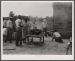 Over this stove, cooking is done for the thirty five migrants that stay in this house in the background. Near Old Trap, North Carolina.